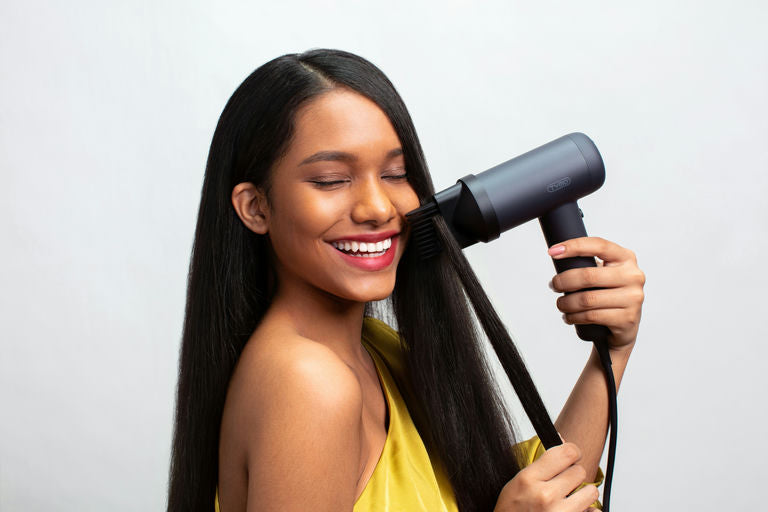 Woman using advanced hair appliances for hair care and styling